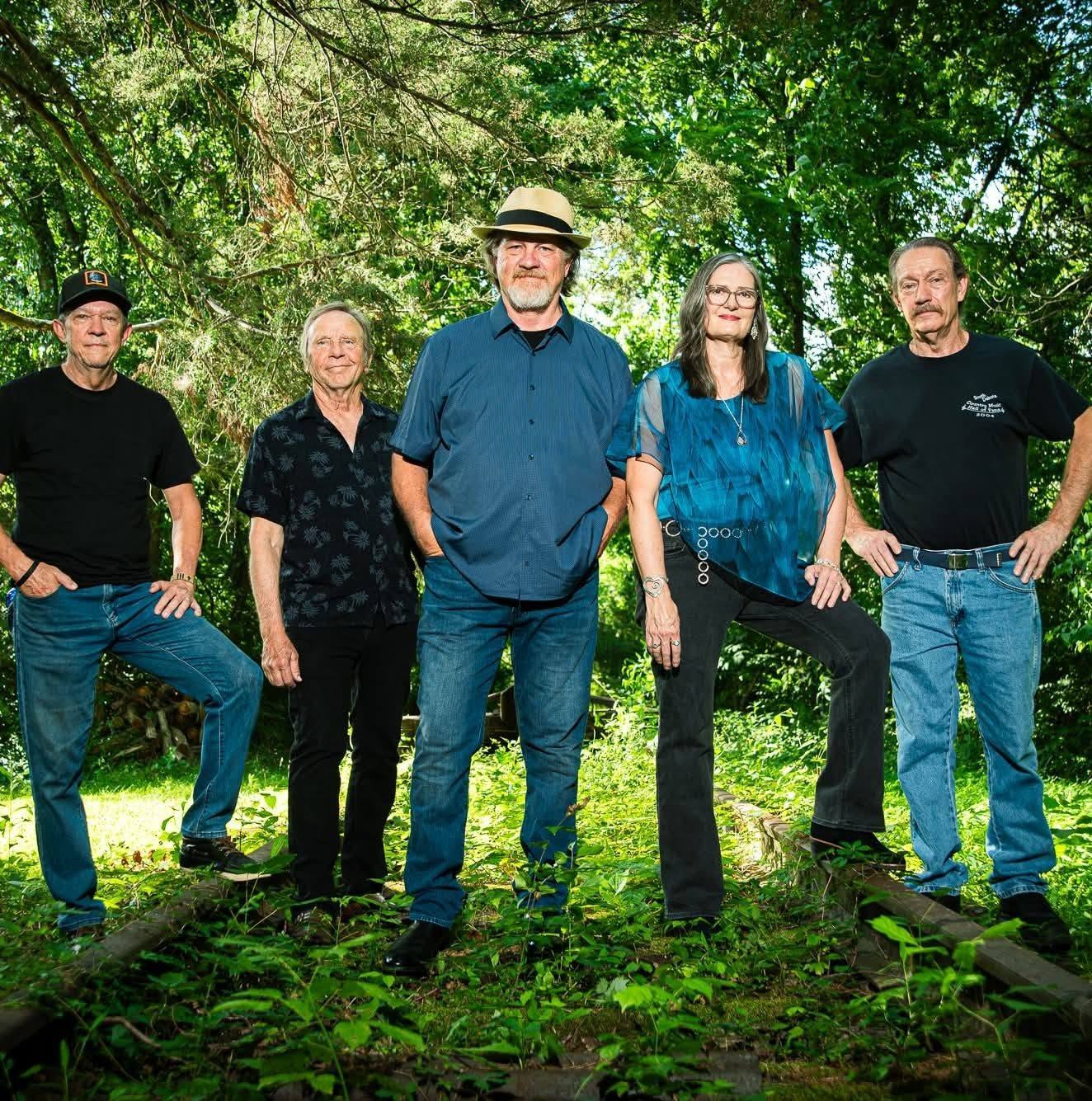 A five member band photographed together on the grounds at Blue Spring Estate