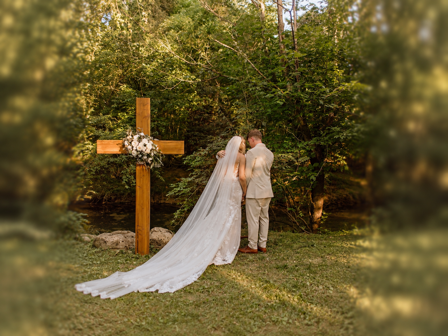 Newlyweds photographed beside the floral cross in the Secret Garden at Blue Spring Estate