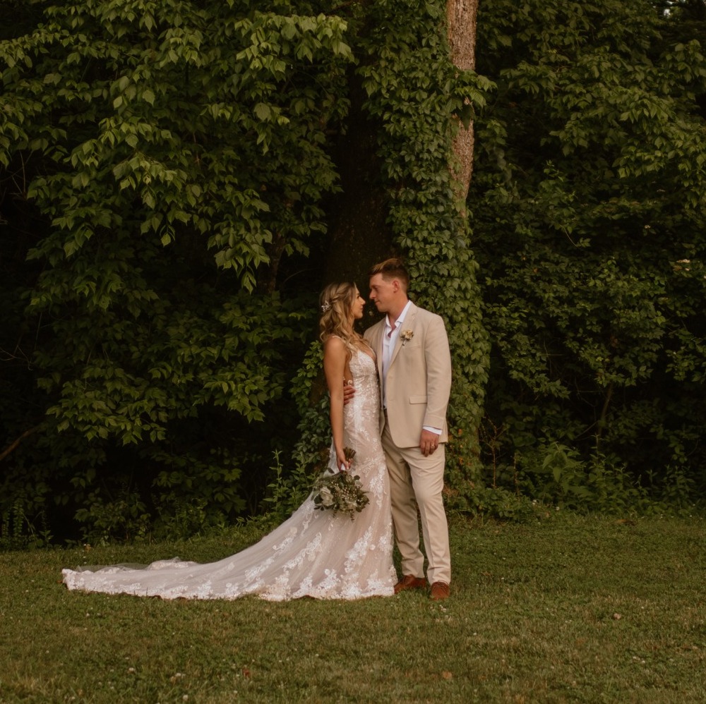 Bride and groom standing beneath a century-old sycamore tree on the Blue Spring Estate grounds